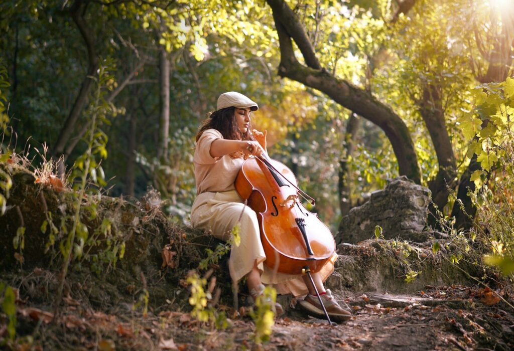 Woman playing cello in a sunlit forest